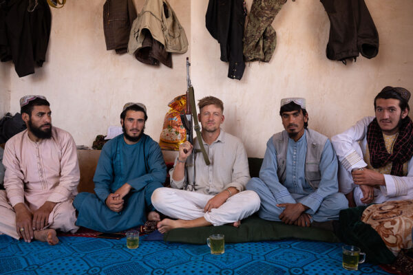overlanding-afghanistan-landrover-defender-11 sitting with talibans holding a ak47