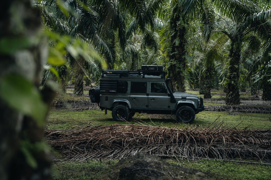 Featured image alt text Our Land Rover Defender driving through palm oil plantations in Malaysia