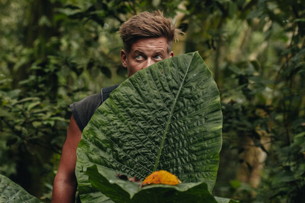 florian hiding behind a giant plant leave