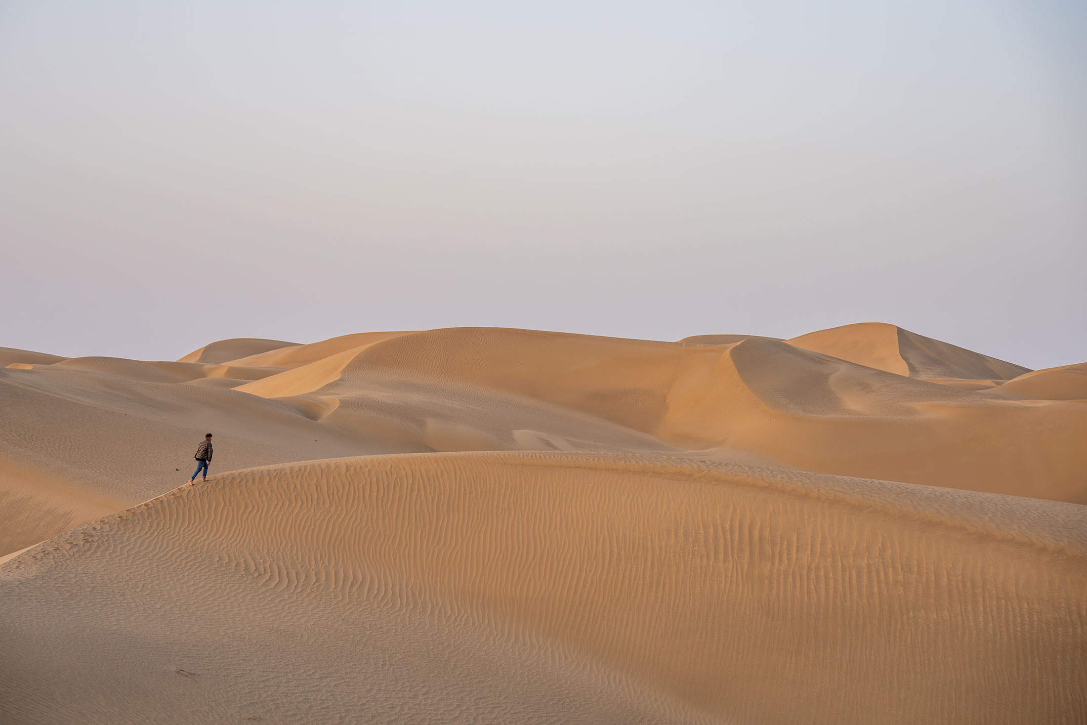 florian is walking on the sand dunes of the taklamakan desert
